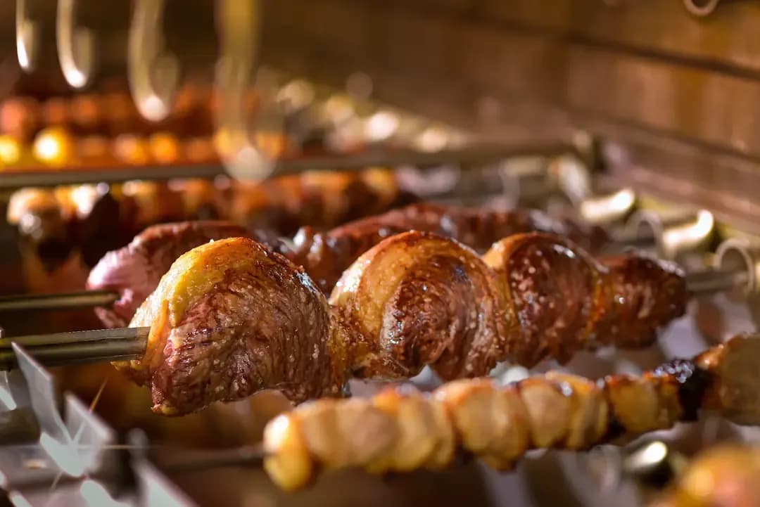Espetos de churrasco assando na brasa